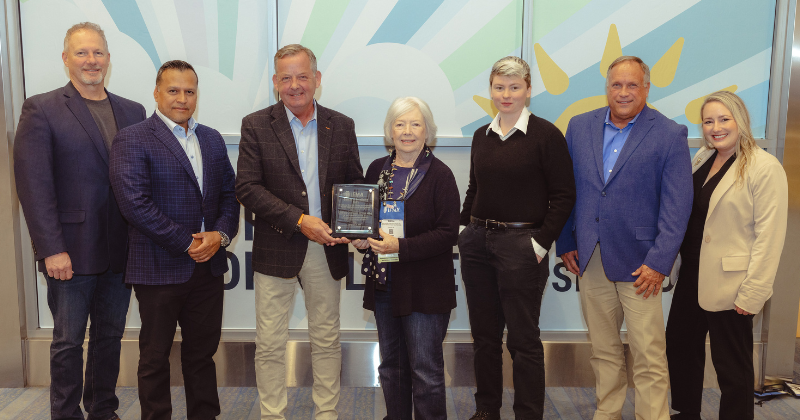 Sheila Sheridan presents the IFMA Awards of Excellence plaque to ESFM President David Hogland, along with other ESFM leaders and associates, during IFMA's 2023 World Workplace in Denver.